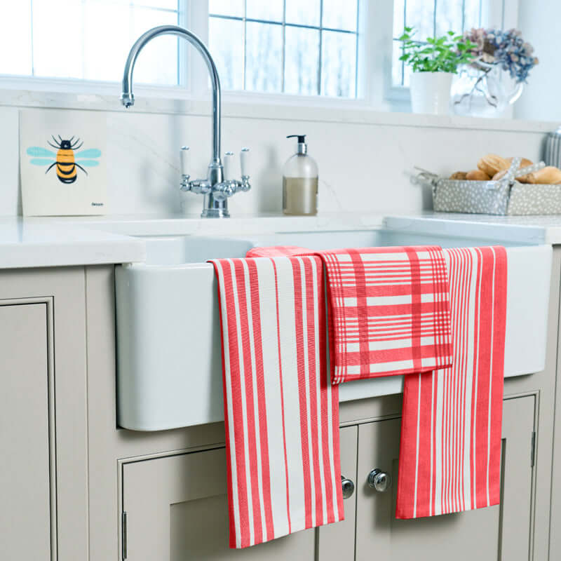 Dexam - Love Colour Set of 3 Extra Large Tea Towel - Scarlet hanging over a kitchen sink with striped and checked patterns.