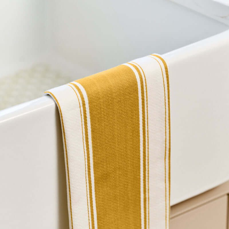 Dexam - Love Colour Tea Towel - Ochre hanging on a kitchen sink with dark ochre yellow and white stripes.