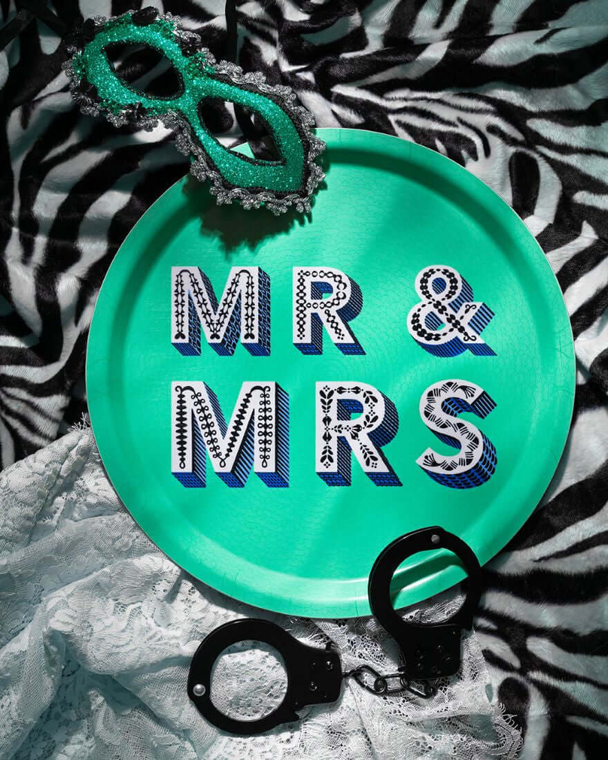 Serving Tray - Asta Barrington "MR & MRS" Green Round Tray (31cm) on zebra print background with mask and handcuffs.