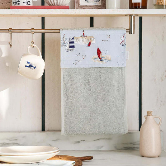Sophie Allport "Coastal Boats" Roller Hand Towel hanging in kitchen, featuring nautical boat designs and soft grey fabric.