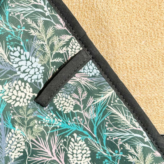 Crisp & Dene Winter Spruce Double Oven Glove featuring a floral design of pine cones and winter foliage.