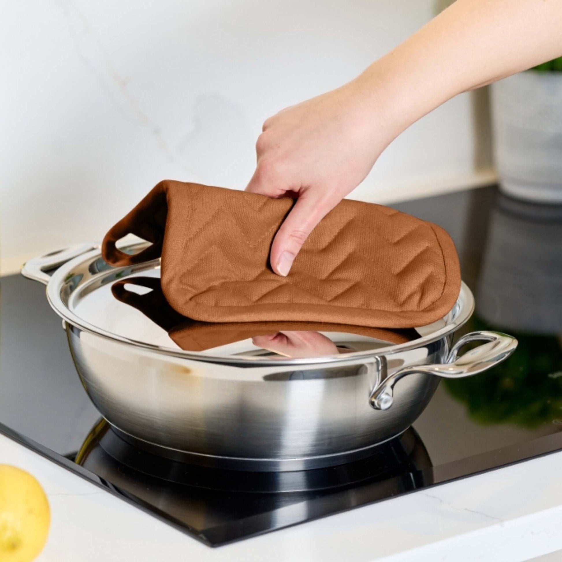 Pot Holder - Dexam - Love Colour - Terracotta being used to grab a pot lid from a stainless steel cookware.