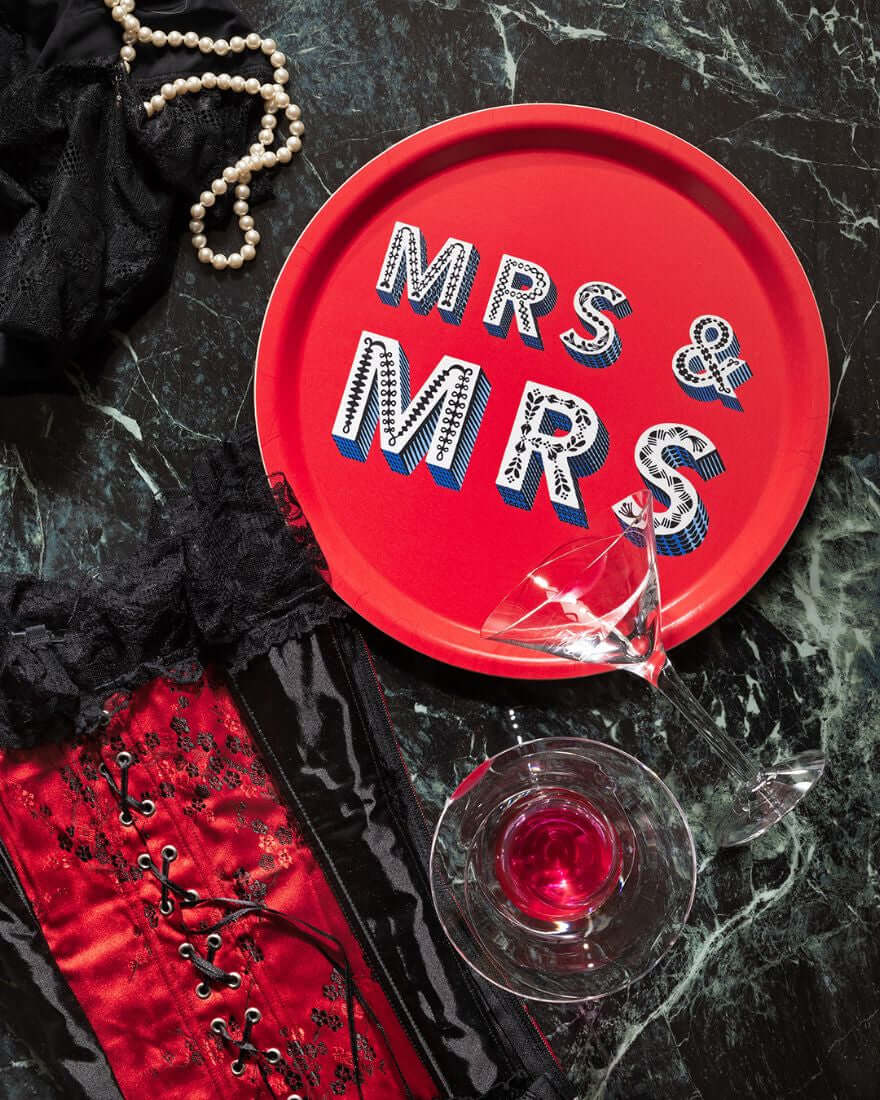Serving Tray - Asta Barrington "MRS & MRS" Red Round Tray (31cm) displayed with stylish accents and a drink.